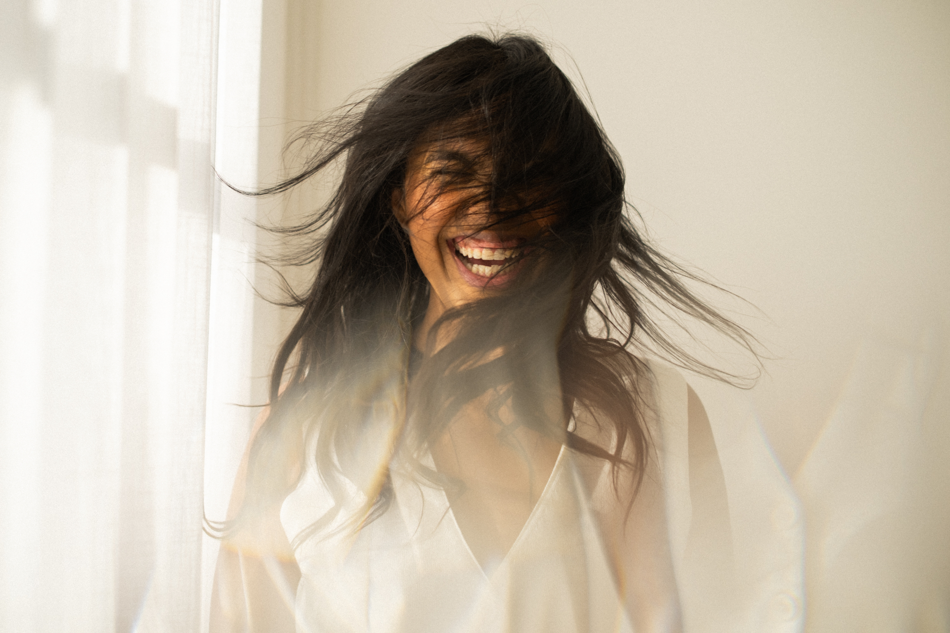 Nathalia Garrote sorrindo com cabelo ao vento
